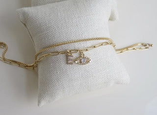 A Beautiful Combination of our Paper Clip and Box Chain, it’s two chains on a single clasp so it’s like a double layer in one.  This Anklet has a diamond evil eye and a petite diamond letters (A-Z). a beautiful Personalized Piece of Jewelry.